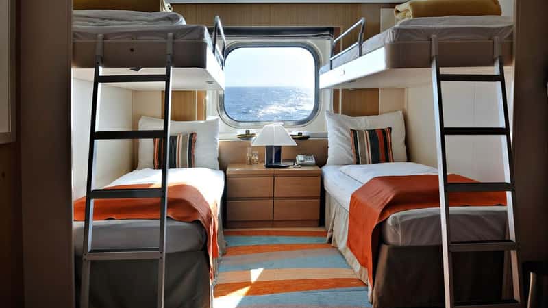 interior of a living cabin on a cruise ship - with bunk beds and window