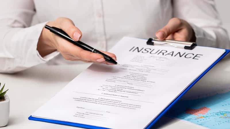 A comprehensive guide on various insurance policies including health, life, and travel insurance, detailing their importance. Documenting a travel insurance form in an office.