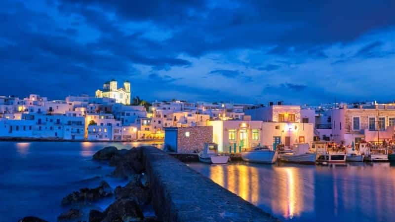 Picturesque view of Naousa town in famous tourist attraction Paros island, Greece with traditional whitewashed houses illuminated in night