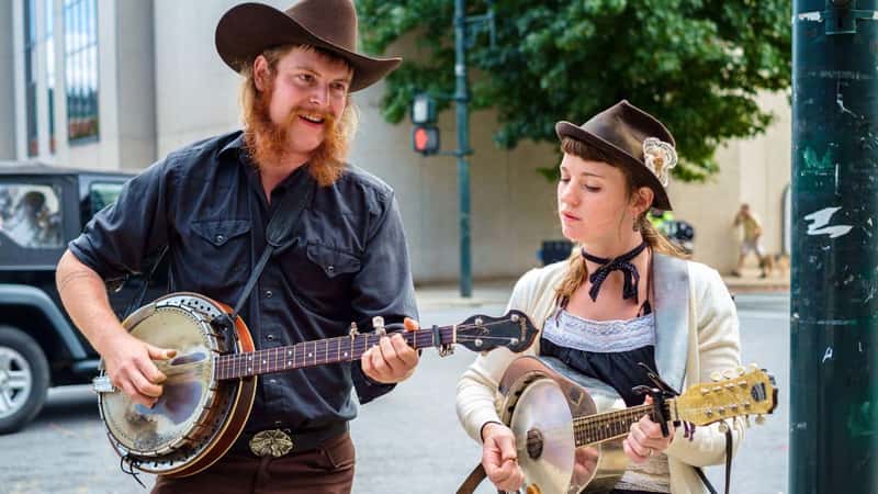 Asheville, North Carolina USA - October 12, 2013: Young street performers playing country music with a banjo and guitar in the historic downtown district of this small southern town.