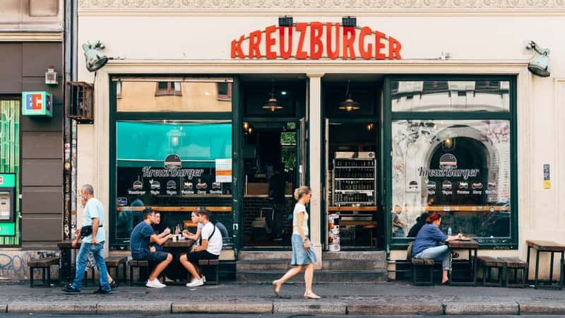 Berlin, Germany - July 29, 2019: Trendy restaurant with tables on sidewalk in Kreuzberg quarter. Kreuzberg is one of the cultural centers of Berlin.