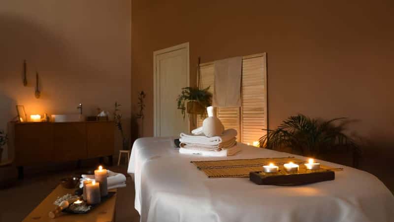 Interior of dark spa salon with tables and burning candles