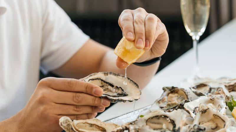 oyster. Man eating shellfish. Seafood and Mediterranean cuisine with mussels in shell. oyster in luxury restaurant.