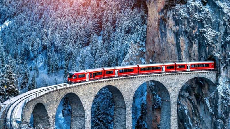 Aerial view of Train passing through famous mountain in Filisur, Switzerland. train express in Swiss Alps snow winter scenery.