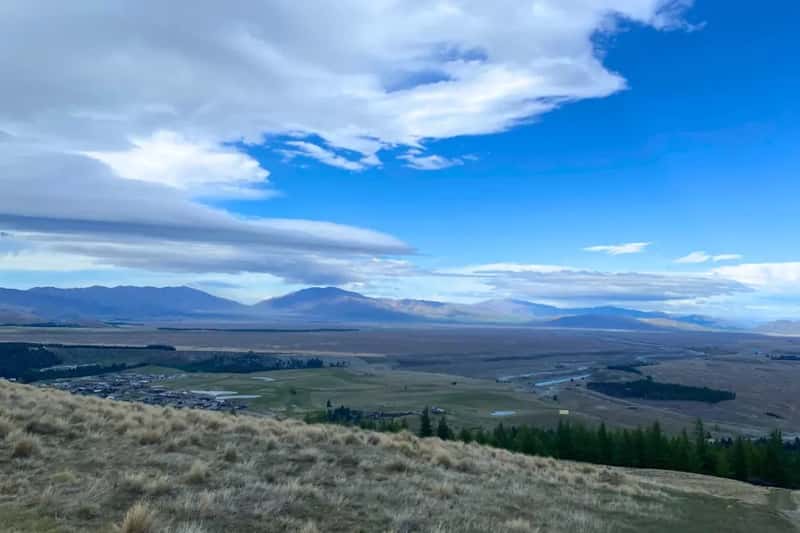 open grassland at the top of mount john with view of southern alps