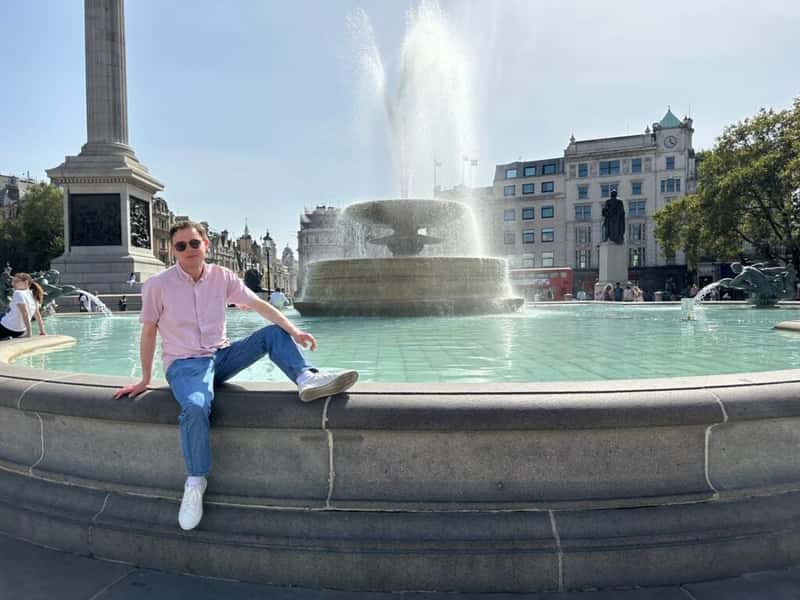 a man in front of a fountain in trafalgar square london