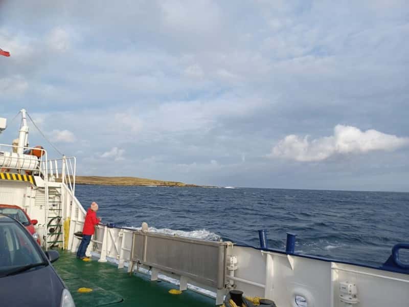 a lady looks over the side of a car ferry crossing the atlantic to papa stour shetland scotland uk