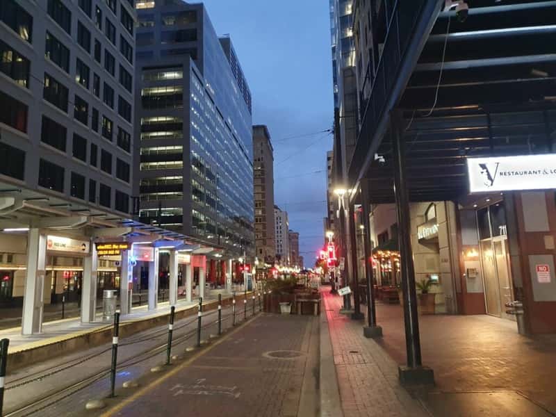a light rail stop on a street in houston texas at night