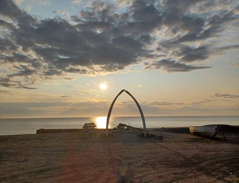 the whalebone arch in Utqiagvik alaska usa on a beach with the arctic ocean in the background at sunset
