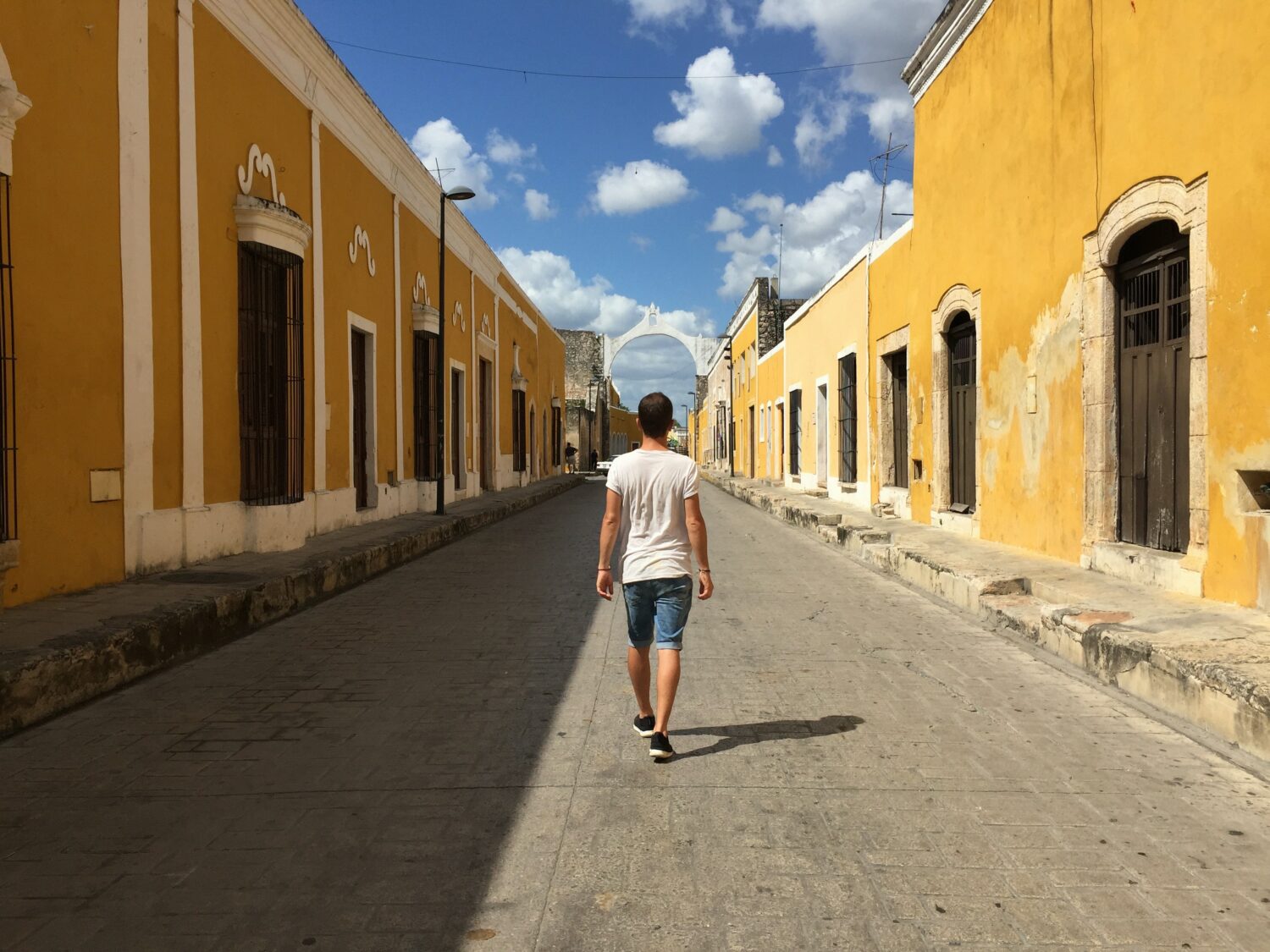 A male tourist walking down the street in Merida, Mexico