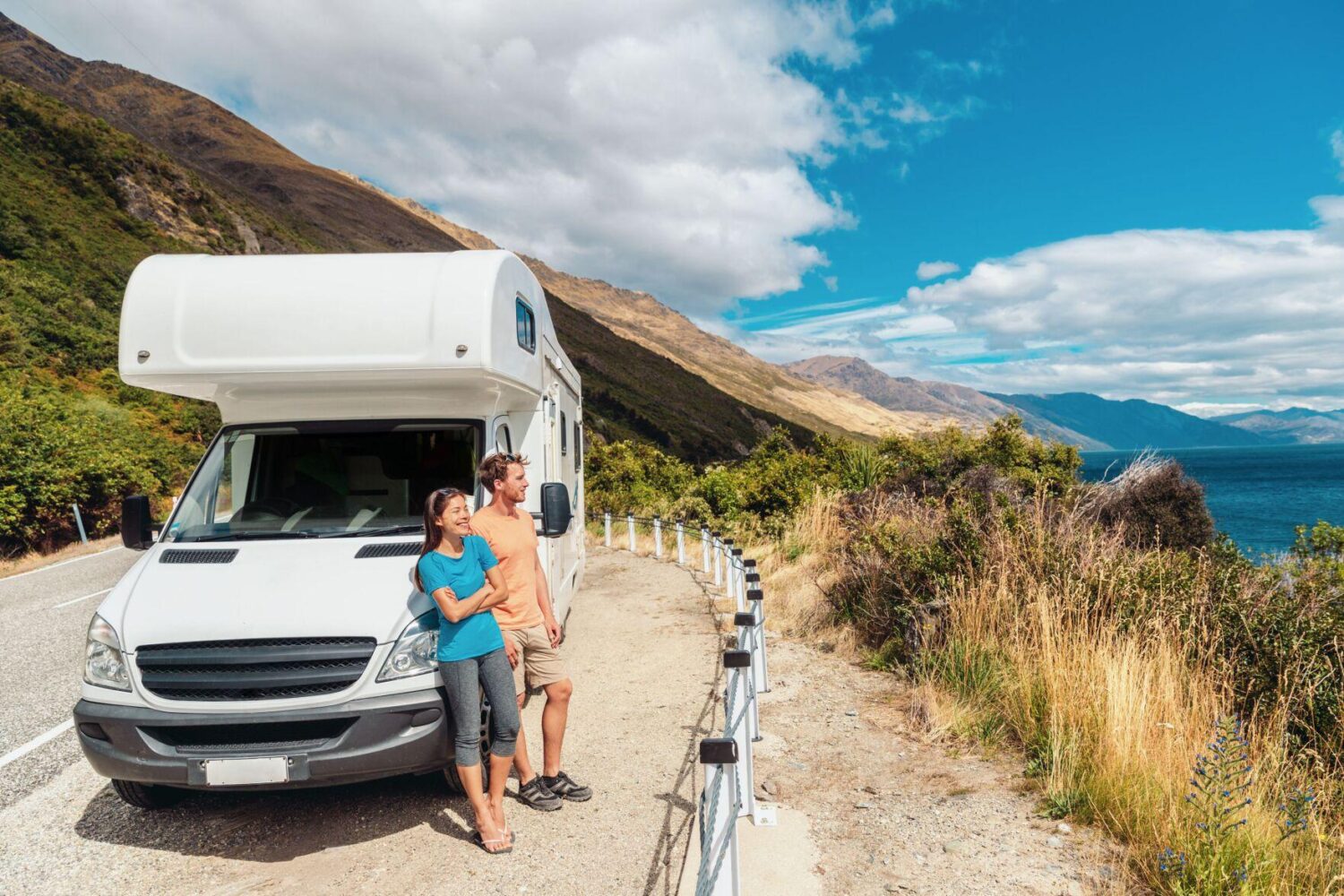 Man and woman in front of RV admiring landscape