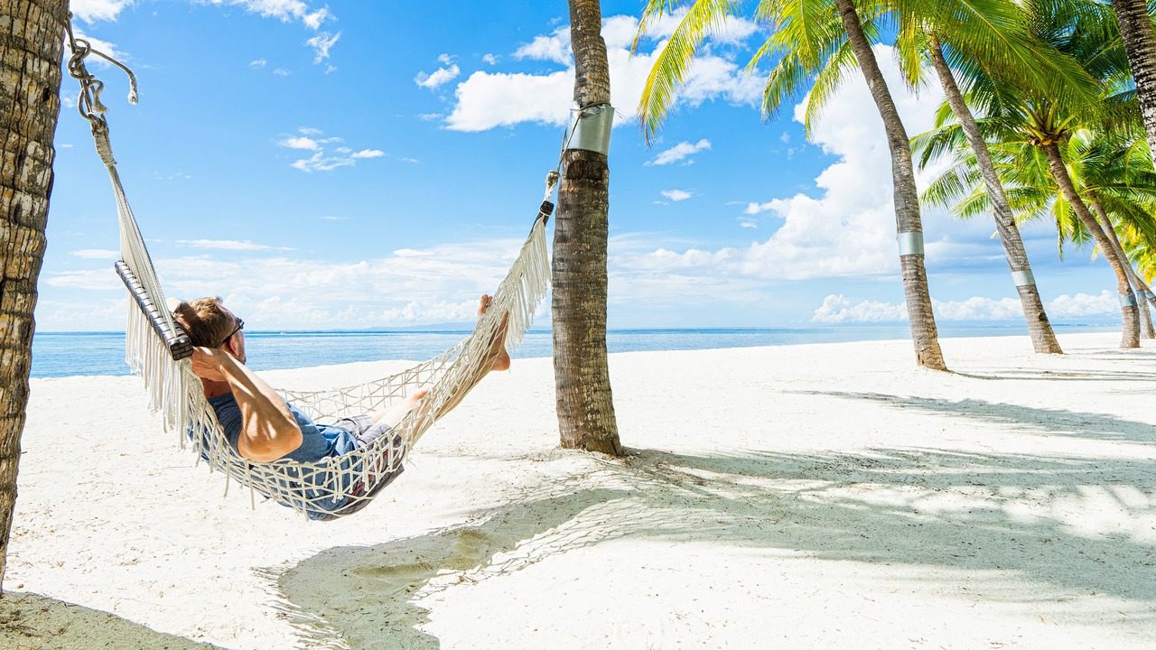 A man relaxing in a hammock on a tropical island.